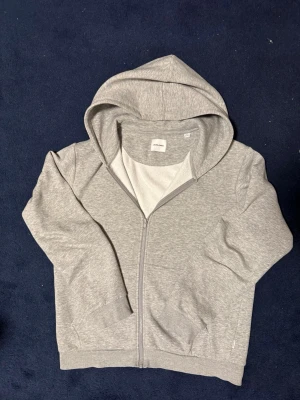 Grå hoodie med dragkedja Jack & Jones - Snygg grå hoodie från Jack & Jones med dragkedja framtill. Storlek M väldigt bra skick! Tveka inte att ställa frågor vid funderingar, pris går att fiskuteras 💯💯