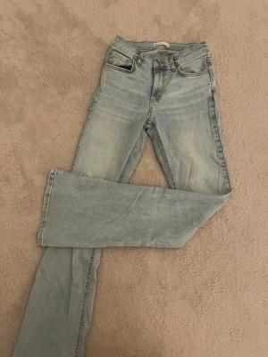 Ljusblå bootcut jeans från Gina Tricot - Snygga ljusblå jeans från Gina Tricot med bootcut passform och klassisk femficksdesign. Jeansen har en något utsvängd benslut och är tillverkade i denim med lätt tvättad look. Perfekta för en avslappnad och trendig stil.