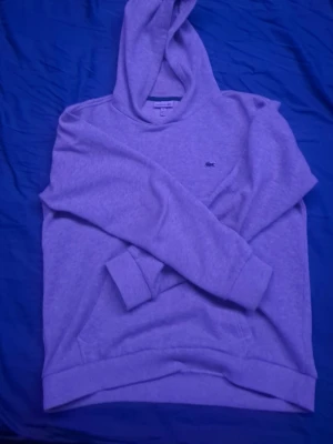 Grå hoodie från Lacoste - Nu säljer jag en grå hoodie från Lacoste som är en perfekt hoodie för dig som vill ha en stilren look och den har använts ett par få gånger!