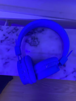 Trådlösa over-ear hörlurar blå - Snygga trådlösa over-ear hörlurar i blått med vadderad bygel och mjuka öronkuddar. Hörlurarna har knappar på sidan för enkel styrning och en stilren, modern design. Perfekta för musik, gaming eller videosamtal.