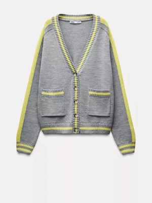 Populär Kofta från Zara - Snygg grå kofta från Zara med gula och ljusgrå ränder längs kanterna och ärmarna. Koftan har v-ringning, knappar framtill och två fickor. Perfekt för lager på lager och en chill look. Materialet är mjukt och stickat.