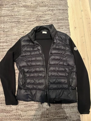 Svart cardiganjacka från Moncler - Tidlös svart cardiganjacka från Moncler i bra skick. Storlek XL men sitter som en L
