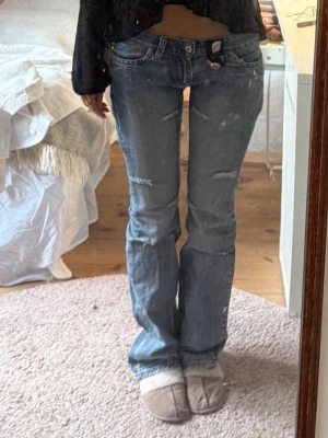 Blå bootcut jeans med slitningar - Säljer ett par blå bootcut jeans från Replay med slitna detaljer och låg midja. Säljer pga att dom inte kommer till användning längre! Dem är i storlek 29, men skulle säga att dom passar mig som har ca. w.25 i true religion. Längd 34, och är förlånga för mig som är 170. Tyvärr är dom lite söndertrampade (bild  5), men inget som syns vid användning. Första bilden syns en knapp som nu är ett hål, men inget som syns vid användning. Hör av er med frågor eller diskuterande av pris!💕💕