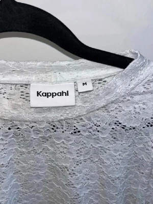 Vit spetsblus från Kappahl - Säljer en vit blus från Kappahl i storlek M. Blusen är helt i spets med puffiga korta ärmar och rund halsringning. Använd 1 gång.