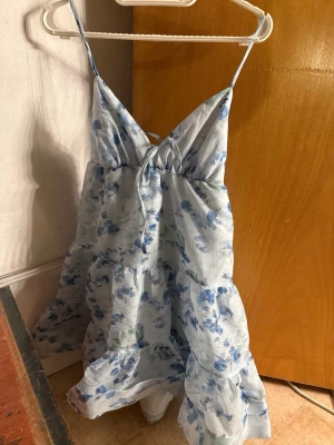 Blommig kortklänning från NA-KD - Söt ljusblå kortklänning från NA-KD med blommigt mönster i blått och vitt. 