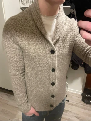 Beige stickad cardigan - Väldigt snygg beige stickad cardigan från Zara. Passar perfekt till kallare väder. Modellen är 180cm, 75kg. Priset kan såklart diskuteras!