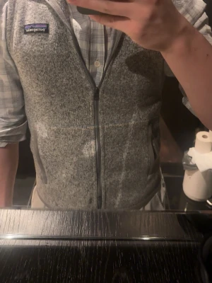 Grå fleeceväst från Patagonia - Snygg gråmelerad fleeceväst från Patagonia. Inga defekter och i perfekt skick. Det är bara att höra av sig vid frågor eller funderingar!