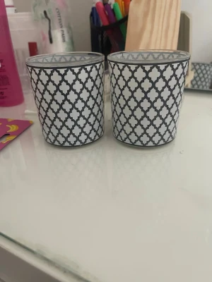 Två glaslyktor med svartvitt mönster - Säljer två snygga glaslyktor med svart och vitt orientaliskt mönster. Perfekta som ljushållare eller dekoration på skrivbordet eller i fönstret. Tillverkade i glas med tryckt mönster på utsidan. Tveka inte på att höra av dig om du har några frågor!💕