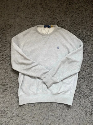 Grå Ralph Lauren tröja - Tja! Jag säljer denna Ralph Lauren tröja i storlek M då den inte passar mig längre. Tröjan är i mycket bra skick utan defekter. Hör av er om ni har några frågor om produkten eller priset😁