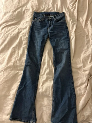 Blå bootcut jeans - Säljer ett par blå bootcut jeans från Gina Tricot med fickor och normal midja. Knappt använda. Lappen inuti jeansen är bortklippt men det är storlek 34!! 