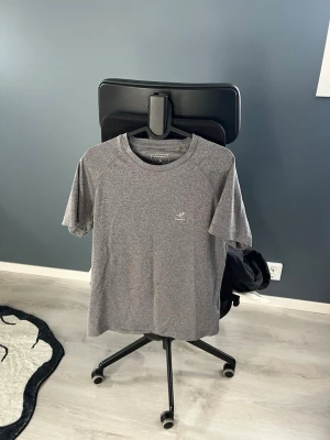 2xGrå tränings-tshirt från Intersport  - Säljer en grå t-shirt från Intersport  med diskret logga på bröstet. T-shirten är kortärmad och har en sportig design, perfekt för träning. Materialet är mjukt och känns som polyester, vilket gör den bekväm och lätt att bära.