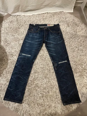 Waxed Selvedge Jeans med design - Ett härligt par distressed & waxed selvedge Jeans i storlek 33. Jeans i hög kvalite och bra tjocklek. Straight leg.  Hör av er vid minsta lilla fundering angående annonsen!