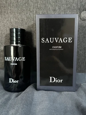 Dior Sauvage Parfum 100ml - Dior Sauvage Parfum är en exklusiv herrdoft i en elegant svart glasflaska med matchande svart kartong. Flaskan har en stilren, rund form och tydlig vit logotyp. Parfymen är känd för sin intensiva och fräscha doftprofil som passar perfekt för dig som vill sticka ut.