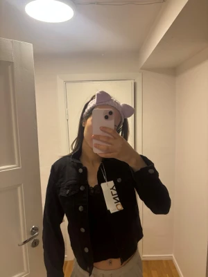 Svart jeansjacka från ONLY XS - Säljer en svart jeansjacka från ONLY i storlek XS. Jackan har klassisk knappstängning framtill, två bröstfickor med lock och en snygg, croppad passform. Perfekt att slänga över en topp för en cool look.