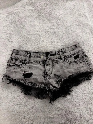 Gråsvarta jeansshorts - Säljer ett par shorts som är low waist gråa men de är ganska små, passar kanske om man har lite smalare ben är kortare 