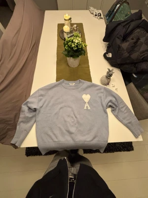 Ljusblå stickad tröja från Ami Paris - Ljusblå stickad tröja från Ami Paris i storlek S. Bra skick men används, kom gärna med frågor och pris förslag :)