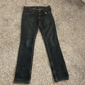 Mörkblå jeans från Lab - Snygga mörkblå jeans från Lab med en klassisk femficksdesign. De har en dragkedja och knapp framtill samt kontrastsömmar som ger en cool look. Perfekta för en avslappnad stil.