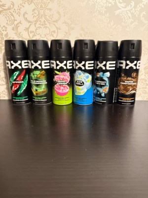 Axe Deospray Mix 6-pack - Säljer ett 6-pack Axe deosprayer i olika dofter: Africa, Wild Mojito & Cedarwood, Epic Fresh, Ice Chill, Harmony for Him och Dark Temptation. Flaskorna är svarta med färgglada detaljer och har en modern, sportig design. Perfekt för dig som vill ha variation i din doftgarderob.