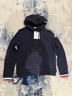 Blå Moncler zip hoodie - Säljer denna super feta Moncler zip Hoodien, ny med tags kvar. Nfc Scan funkar. Inget kvitto finns! Pris kan diskuteras vid snabb affär! Han på bild är 178, 67kg