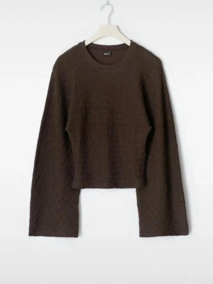 Brun långärmad topp med vid ärm - Mörkbrun långärmad topp med vid passform och extra vida ärmar. Tröjan har en lätt struktur i materialet och rund halsringning. Perfekt till jeans för en avslappnad look.