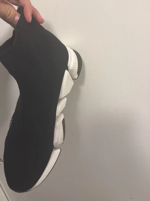 Svarta sock sneakers med chunky sula - Skriv privat för mer bilder för de funkar inte o ladda upp fler Säljer ett par svarta sock sneakers med vit chunky sula. Skorna har en strumpliknande ovandel i stretchigt tyg och en unik, segmenterad sula som ger en futuristisk vibe. Perfekta för dig som gillar streetwear och vill ha något som sticker ut. 