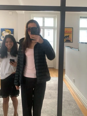 Svart pufferjacka med horisontella paneler - Säljer en svart pufferjacka med horisontella paneler och dragkedja framtill. Jackan är från peak performance .