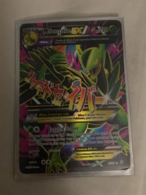 Pokémonkort Mega Sceptile EX - Unikt Pokémonkort med Mega Sceptile EX, 220 HP. Kortet har en färgstark design med gröna, gula och rosa detaljer samt japansk text. Kortet är av typen EX och har attacken Jagged Saber. Perfekt för samlare eller Pokémonfans.