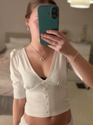 Super söt topp, Stradivarius - Vit gullig topp från Stradivarius med urringning och knappar. Den är i storlek S men den passar mig som brukar ha XXS/XS 🩷