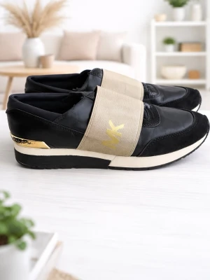 Svarta sneakers från Michael Kors storlek 38 - Michael Kors  Svarta sneakers med guldfärgade detaljer. Skorna har en bred resårrem över vristen med Michael Kors-logotypen i guld. Sulan är svart och vit med en räfflad undersida. alla skick visas på bilderna