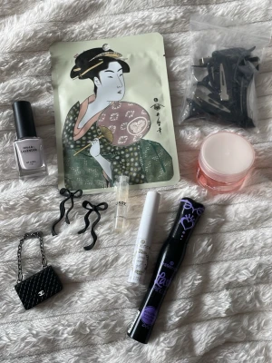 Mixat kit med skönhetsprodukter och accessoarer - Ett skönhetskit med ansiktsmask med japanskt motiv, svart C-inspirerad miniväska, svart nagellack från Lyko i Lavender, Essence mascara och brow gel, svart hårklämmor, parfymprov Libre YSL, rosa gel mask och svarta rosett örhängen. En del nytt, en del använt men ytterst lite. Allt för 35:-