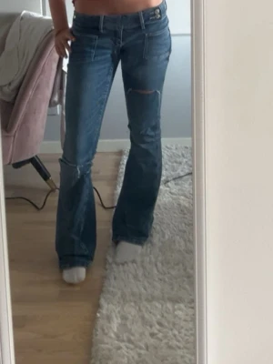 Blå bootcut jeans med slitningar - Super fina! Knappt använda så i fint skick! Skriv om ni har frågor eller funderingar! Storlek 34