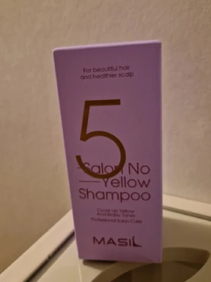 Masil 5 Salon No Yellow Shampoo - Lila förpackning med Masil 5 Salon No Yellow Shampoo, ett professionellt silverschampo som neutraliserar gula och varma toner i håret. Perfekt för dig som vill ha kallare nyanser och fräscht hår. Kommer i en stilren, rektangulär kartong. HAR 4 AV DESSA SÅ LÄGGER UP MÅNGA ANNONSER