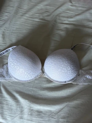 Vit push-up bh - Vit push-up bh i vitt leopard mönster. Den är i storlek 80B. Den har någon brun utan sol fläck på insidan men inget som syns när man har på sig den (luktar inte heller)
