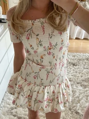 Blommig off shoulder klänning - Jättesöt blommig off shoulder klänning med smockad överdel och volang kjol!💓 klänningen är i storlek S och är helt slutsåld från H&M. Lånade bilder, men den är exakt som på bilden. Skriv privat för fler bilder. Använd fåtal gånger så mycket bra skick!💓💓