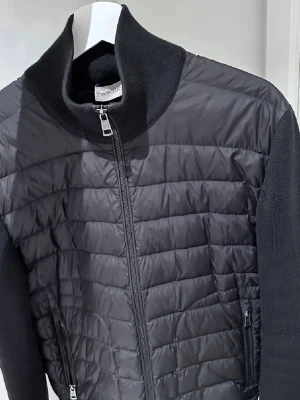 Svart Moncler cardigan  - Tja, säljer min Moncler cardigan den är i storlek L men passar M. Säljer pga den kommer inte till användning. Jackan har två defekter, bild finns på 5,6 inget som syns. Hör av er om ni har några frågor.