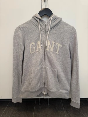 Zip hoodie GANT - Äkta GANT full zip hoodie i ljusgrått. 