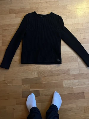 Svart replay ribbstickad tröja - En svart ribbstickad tröja med rund hals och långa ärmar. Tröjan har en rak passform och är tillverkad i ett mjukt stickat material. Perfekt för lager på lager och enkel att matcha med olika outfits. Den e riktigt skön och stretchig samt så passar den till många olika stilar med bootcut eller straight fit byxor👍skulle säga att den passar nån som e 177