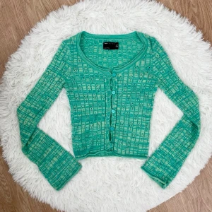 Grön mönstrad cardigan från Asos Design - Trendig grön cardigan med unikt geometriskt mönster från Asos Design. Storlek: XS (34), passar även 36 om du har smala armar och byst under 85cm.