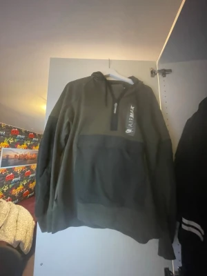 Nike Air Max hoodie och byxor  i olivgrönt - Säljer en olivgrön Nike Air Max hoodie och byxor med svart dragkedja och stor magficka. Tryck med Air Max-logga och Nike Swoosh på bröstet. Hoodien har justerbar huva med snören och är tillverkad i mjukt material, perfekt för en avslappnad streetwear-look.