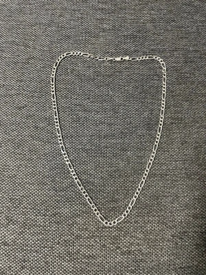 Silverfärgat kedjehalsband - Stilrent halsband i silverfärg med klassisk kedjedesign. Länkarna är ovala och platta, vilket ger ett modernt och tidlöst intryck. Perfekt för att lyfta vilken outfit som helst. Halsbandet har ett smidigt lås och passar både till lager-på-lager eller ensamt.