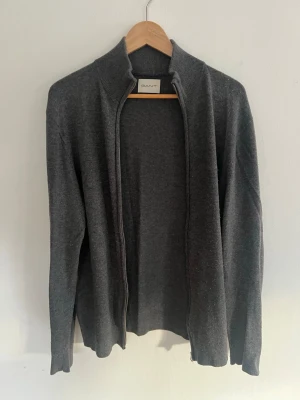 Mörkgrå ziptröja Gant - Mörkgrå ziptröja/kofta från Gant i ull. Storlek XL men sitter som en L. 