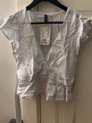 Randig omlottopp - Så himla snygg topp ifrån hm i linnen material! (Den har legat i garderoben och är därför så skrynklig🥲). Den är helt ny med prislapp men har en super liten smink fläck på sig (se bild 2)🥰 skicka om du vill ha bild på!! 