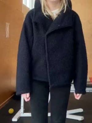 Svart teddyjacka med krage - Mysig mörkblå kappa med hög krage och avslappnad passform. Perfekt för kyligare dagar och enkel att matcha med olika outfits. Den är i en storlek L men passar mig perfekt som vanligtvis brukar ha S eller M i jackor❣️