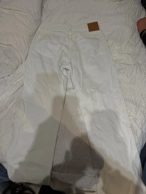 Vita raka jeans från Weekday - Säljer ett par vita jeans från Weekday med rak passform och hög midja. Jeansen har klassiska fem fickor och bälteshällor. Materialet är kraftig denim i bomull och modellen är enkel och stilren. Perfekta till en avslappnad look.