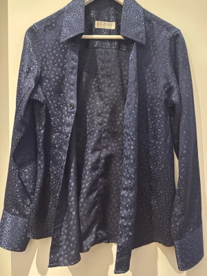 Mörkblå leopardmönstrad skjorta - Snygg mörkblå skjorta. Perfekt för dig som vill sticka ut med ett djurmönster och en cool vibe.