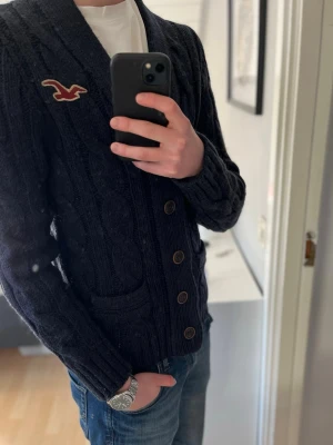 Vintage hollister Tröja - Säljer nu denna otroligt snygga vintage Hollister cardigan i färgen marinblå. Tröjan är i skick 8/10. Hoodien är i storlek M och modellen på bilden är 183 och väger 67 kilo. Priset är inte hugget i sten. Skriv om ni har mer funderingar 😊 