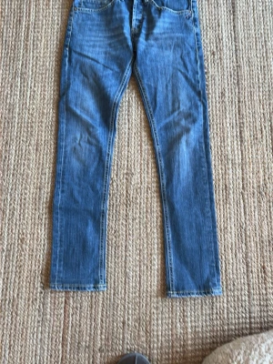 Blåa Dondup jeans - Säljer ett par blåa dondup jeans med rak passform och normal midja. Jeansen har fem fickor och klassiska kontrastsömmar. Tillverkade i denim med en snygg tvättad look. Perfekta till en avslappnad stil.