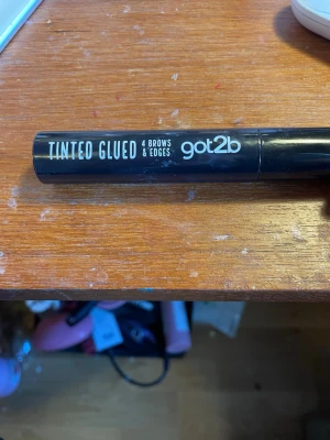 got2b Tinted Glued Brow Gel - Ögonbrynsgel från got2b i svart tub med texten 'Tinted Glued 4 Brows & Edges'. Perfekt för att forma och färga brynen med en naturlig look. Enkel att applicera och håller brynen på plats hela dagen.