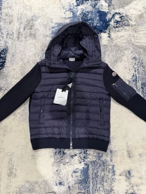 Mörkblå Moncler Cardigan - Helt ny marinblå Moncler Cardigan. Bästa möjliga kvalité. Storlek L men sitter mindre. Han på bild är 178cm, väger 69kg. Pris kan diskuteras vid snabb affär! Längd 60cm. Bredd 48cm