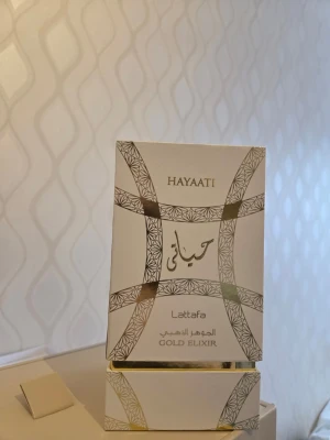 Lattafa Hayaati Gold Elixir parfym - Exklusiv parfym från Lattafa, Hayaati Gold Elixir, i en elegant glasflaska med gulddetaljer och matchande förpackning. Doften är orientalisk och lyxig, perfekt för dig som vill sticka ut.  Helt ny, oanvänd, endast testad EN gång. 
